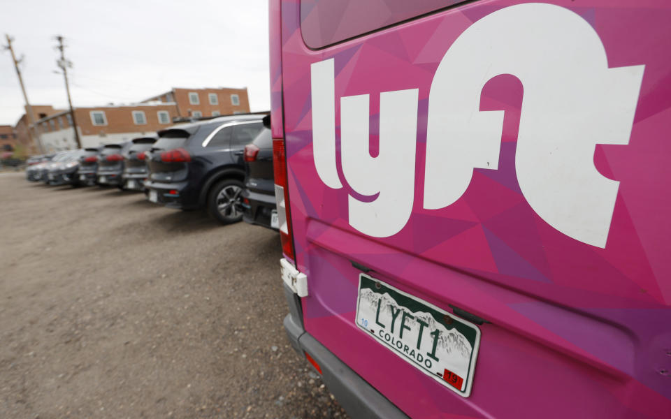 FILE - In this April 30, 2020, file photo, Kia Neros that are part of the Lyft ride-hailing fleet sit unused in a lot near Empower Field at Mile High in Denver. Lyft is still feeling the pandemic’s severe impact on the ride-hailing industry. But its third-quarter results show signs of a recovery from the previous three months when passengers stayed locked down. (AP Photo/David Zalubowski, File)