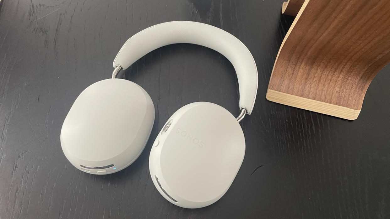  Sonos Ace headphones in soft white finish lying flat on a table. 