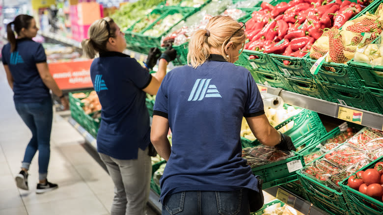 Aldi employees stocking produce