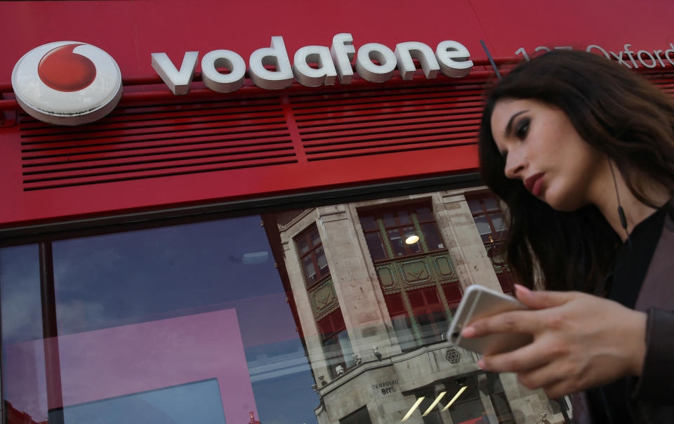 Pedestrians walk past a Vodafone store in central London on May 16, 2017. - Vodafone logged today a large annual net loss after slashing the value of its troubled Indian division, but underlying earnings soared on a solid European performance. (Photo by Daniel LEAL / AFP) (Photo by DANIEL LEAL/AFP via Getty Images)