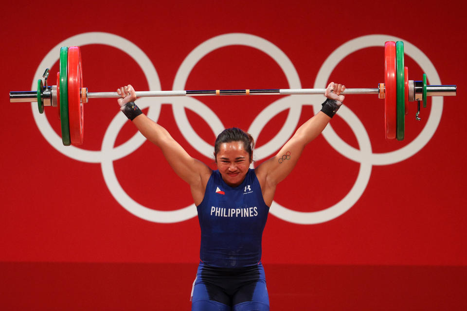 Hidilyn Diaz of Team Philippines lifts weights over her heard