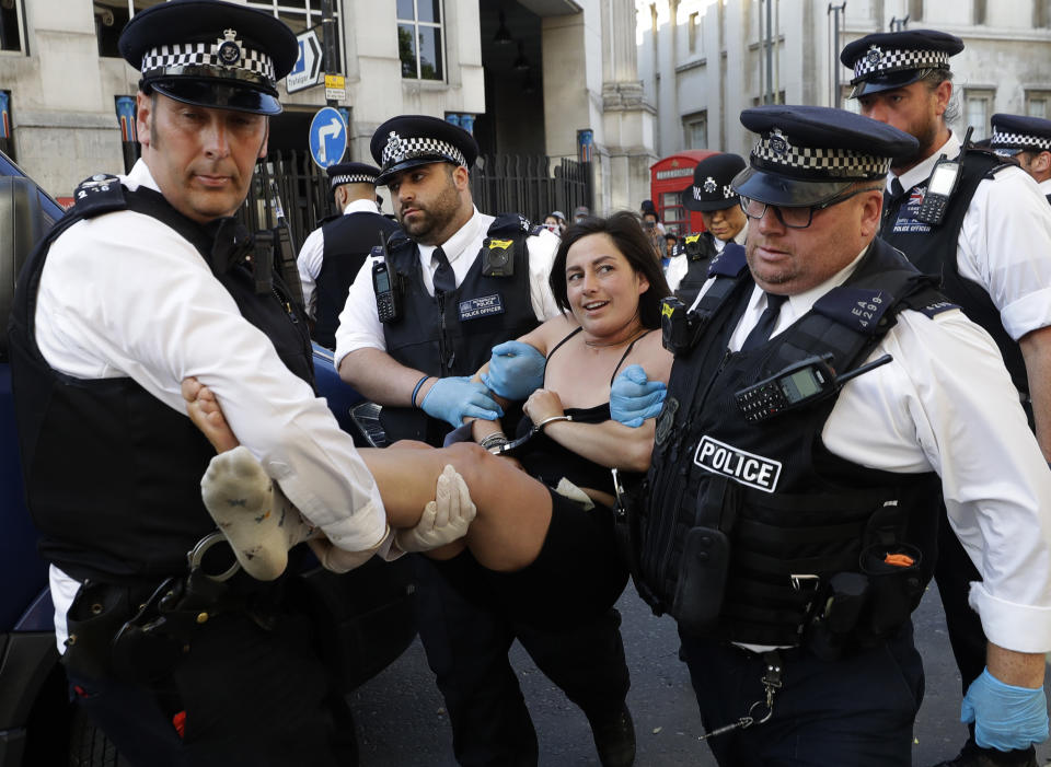 An Animal Rights activist is arrested after she locked herself to another campaigner and blocked the road outside Canada House in London, on Friday, June 26, 2020. The campaigners were protesting and petitioning against Ontario Bill 156, a law aimed at curbing activism against farms and farming practices. (AP Photo/Kirsty Wigglesworth)