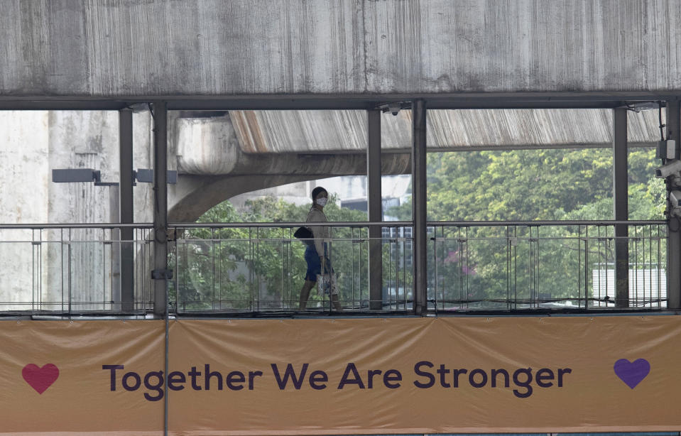 A woman wears a protective face masks to help curb the spread of the coronavirus as she crosses a pedestrian bridge in Bangkok, Thailand, Thursday, April 2, 2020. The new coronavirus causes mild or moderate symptoms for most people, but for some, especially older adults and people with existing health problems, it can cause more severe illness or death. (AP Photo/Sakchai Lalit)