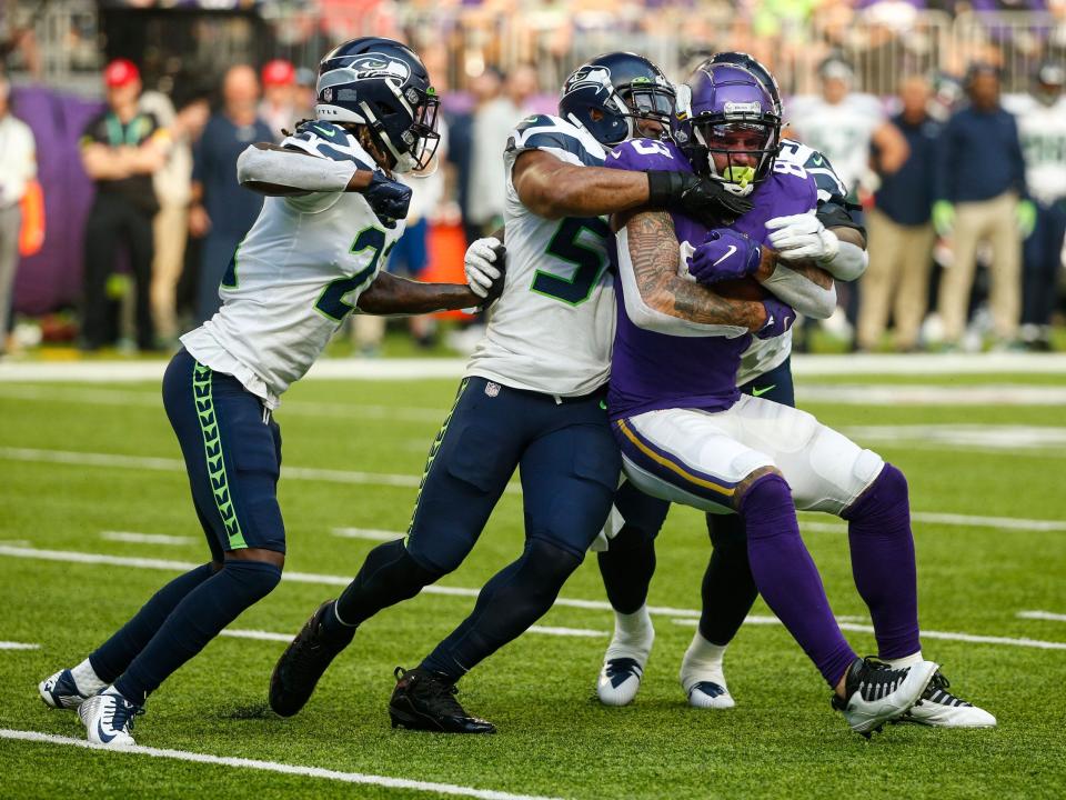 Tyler Conklin fights through tackles against the Seahawks.