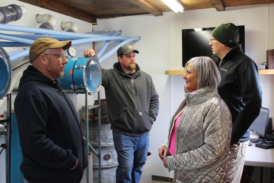 Jeremy Walters, owner of Wagner's Sugar Camp near Salisbury, and his helper, Cody Simmons, show Marcus Harrigan and Julie Kelley, both of Frostburg, Maryland, the technology of releasers and a monitoring system during the Maple Taste and Tour on Saturday.