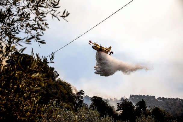 PHOTO: A Canadair aircraft drops water over a wildfire raging near the city of Massarosa, Italy, on July 20, 2022. (Federico Scoppa/AFP via Getty Images)