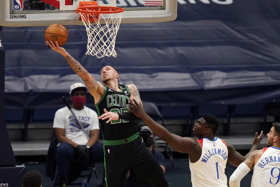 Boston Celtics center Daniel Theis goes to the basket against New Orleans Pelicans forward Zion Williamson (1) in the first half of an NBA basketball game in New Orleans, Sunday, Feb. 21, 2021. (AP Photo/Gerald Herbert)