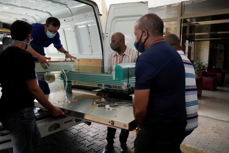 Empleados descargan una máquina fabricada en Cuba que se utilizará para el diagnóstico de la enfermedad del coronavirus (COVID-19) en medio de la preocupación por su propagación, en La Habana, Cuba.