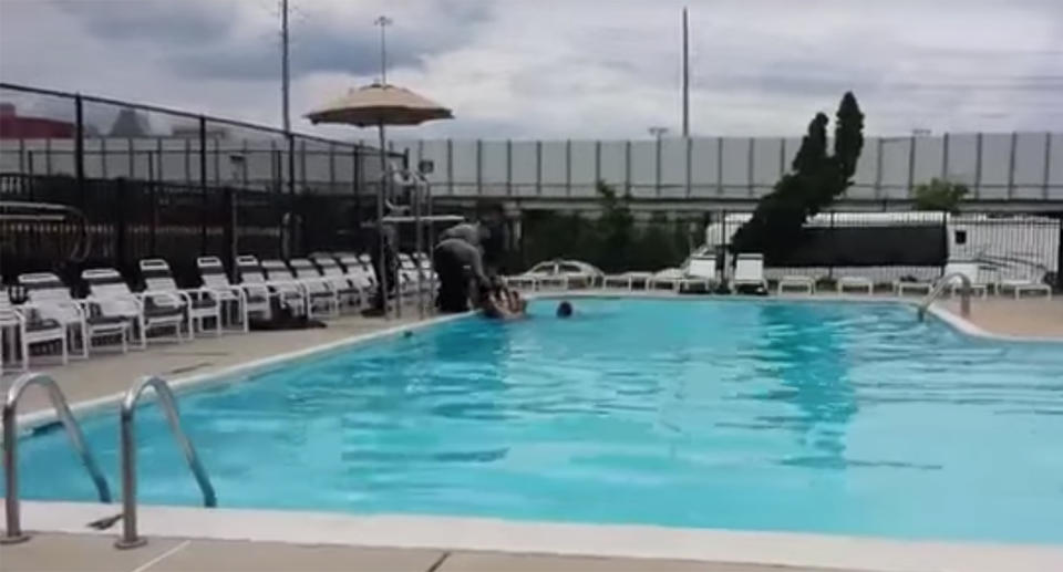 Police can be seen dragging Mr Fijalkowski out onto the edge of the pool. Source: YouTube/Robinhood Esq