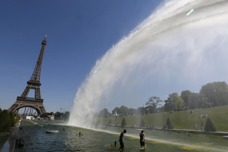 People cool off in the Trocadero fountains on a hot day near the Eiffel Tower in Paris