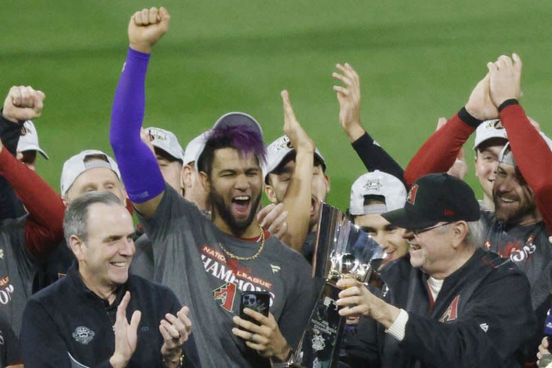 Arizona Diamondbacks manager Torey Lovullo (R) holds the NLCS trophy after a win over the Philadelphia Phillies in Game 7 of the National League Championship Series on Tuesday at Citizens Bank Park in Philadelphia. Photo by Laurence Kesterson/UPI