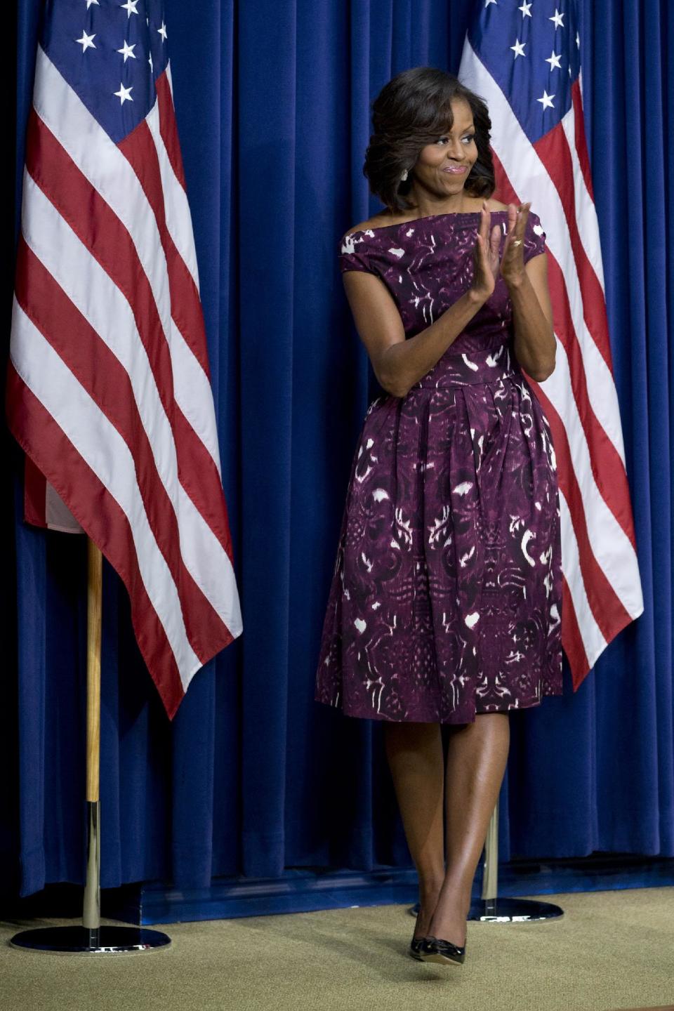 FILE - This July 10, 2013 file photo shows first lady Michelle Obama applauding after speaking to mayors and other officials about the initiative, "Let’s Move! Cities, Towns and Counties," in the Eisenhower Executive Office Building on the White House complex in Washington. Kanye West says when it comes to fashion, Kim Kardashian reigns supreme over every woman, including Michelle Obama. In an interview Tuesday, Oct. 29, with Ryan Seacrest, the rapper said he and his fiancé are “the most influential with clothing.” Despite West’s words, the first lady is a fashion trendsetter and clothes she’s worn have sold out quickly after she's worn them in public. (AP Photo/Jacquelyn Martin, File)