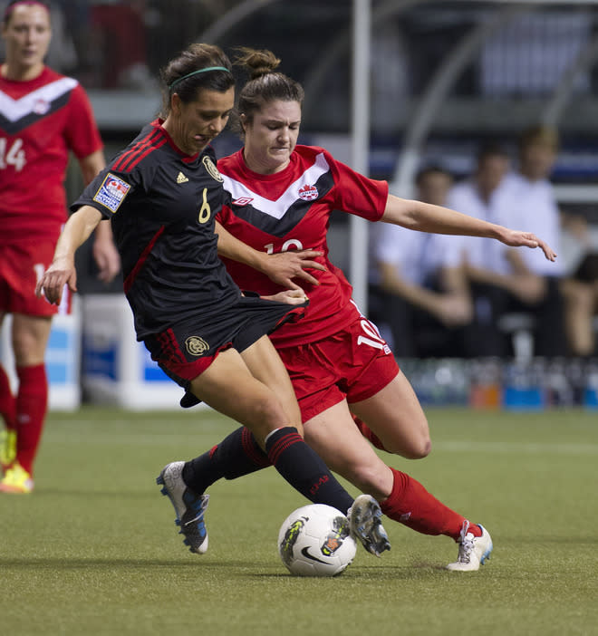 VANCOUVER, CANADA - JANUARY 27: Marylin Diaz #8 of Mexico tries to fend off the challenge of Christina Julien #10 of Canada during the first half of semifinals action of the 2012 CONCACAF Women's Olympic Qualifying Tournament at BC Place on January 27, 2012 in Vancouver, British Columbia, Canada. (Photo by Rich Lam/Getty Images)