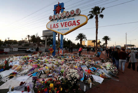 The "Welcome to Las Vegas" sign is surrounded by flowers and items, left after the October 1 mass shooting, in Las Vegas, Nevada U.S. October 9, 2017. REUTERS/Las Vegas Sun/Steve Marcus