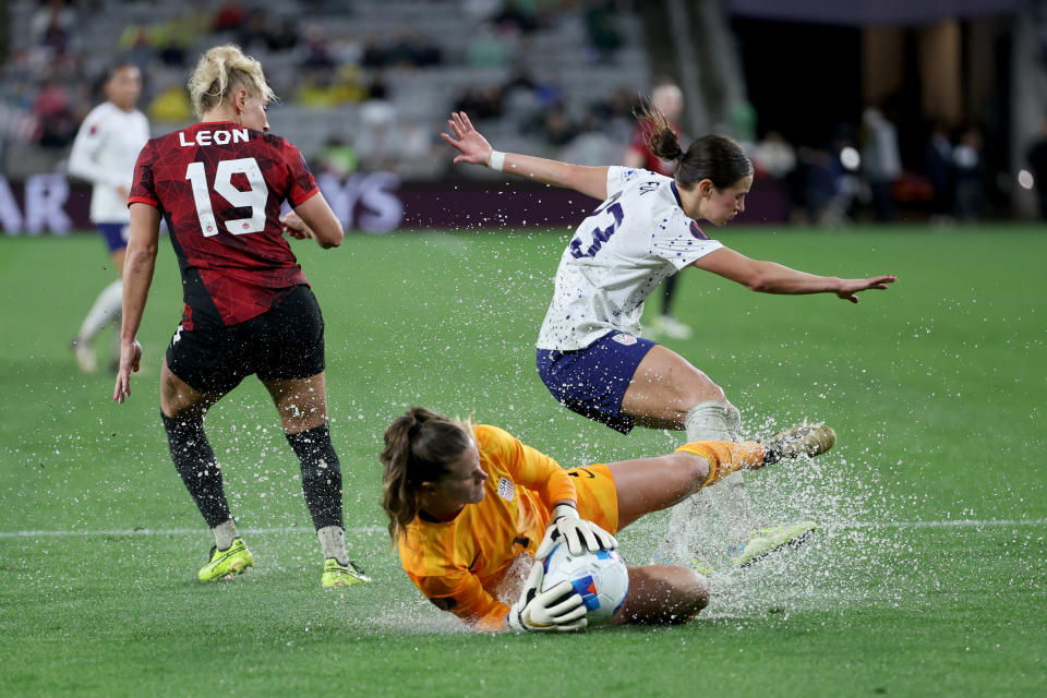 La portera estadounidense Alyssa Naeher se desliza para segurar frente a su compañera Emily Fox y la canadiense Adriana Leon durante la segunda mitad de la Semifinal de la W Gold Cup. (Foto: Sean M. Haffey/Getty Images)