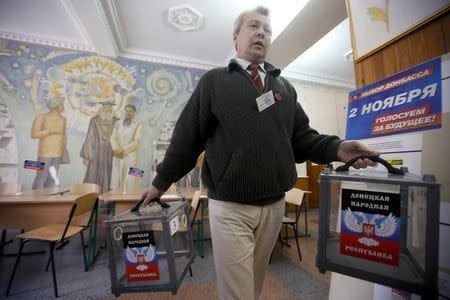 A member of a local electoral commission carries ballot boxes during preparations for the upcoming election, at a polling station in Donetsk, eastern Ukraine November 1, 2014. REUTERS/Maxim Zmeyev