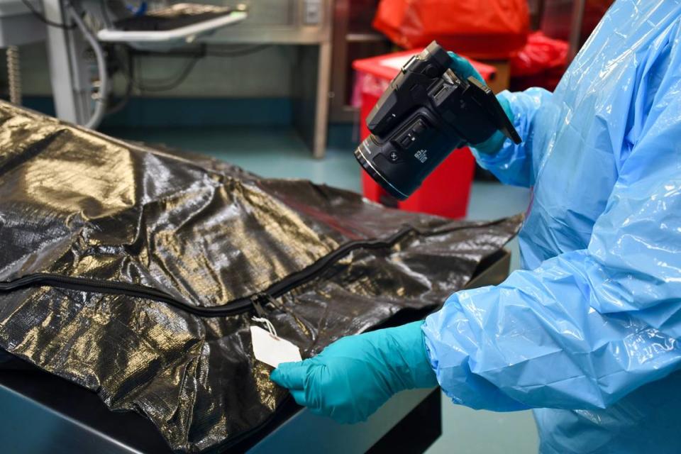 A staff member at the chief medical examiner’s office in Raleigh photographs the identity tag of a person who has died.