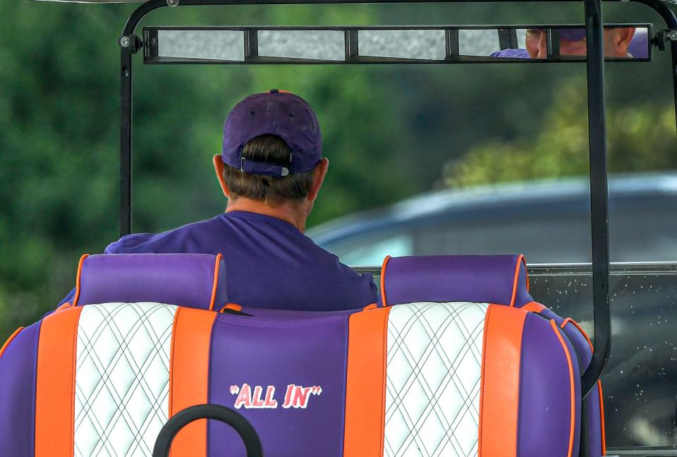 Clemson head coach Dabo Swinney rides a golf cart to practice in Clemson Friday, August 12, 2022. 