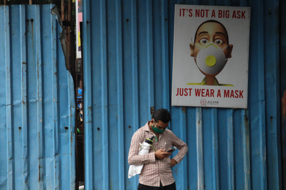 A man uses a mobile phone in front of an Its Not A Big Ask, Just Wear A Mask banner in Mumbai, India on August 12, 2020. India is the third worst-hit nation by the Coronavirus (COVID-19) pandemic after the United States and Brazil. (Photo by Himanshu Bhatt/NurPhoto via Getty Images)