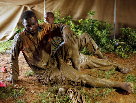 Artisanal miners Thnkmore Mandimutsa and Simon Mushonga sit in a tent after being rescued as retrieval efforts proceed for trapped illegal gold miners in Kadoma, Zimbabwe, February 16, 2019. REUTERS/Philimon Bulawayo