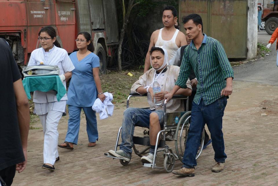 Nepalese people wheel an injured man into an open area at Lalitpur on April 25, 2015.  (PRAKASH MATHEMA/AFP/Getty Images)