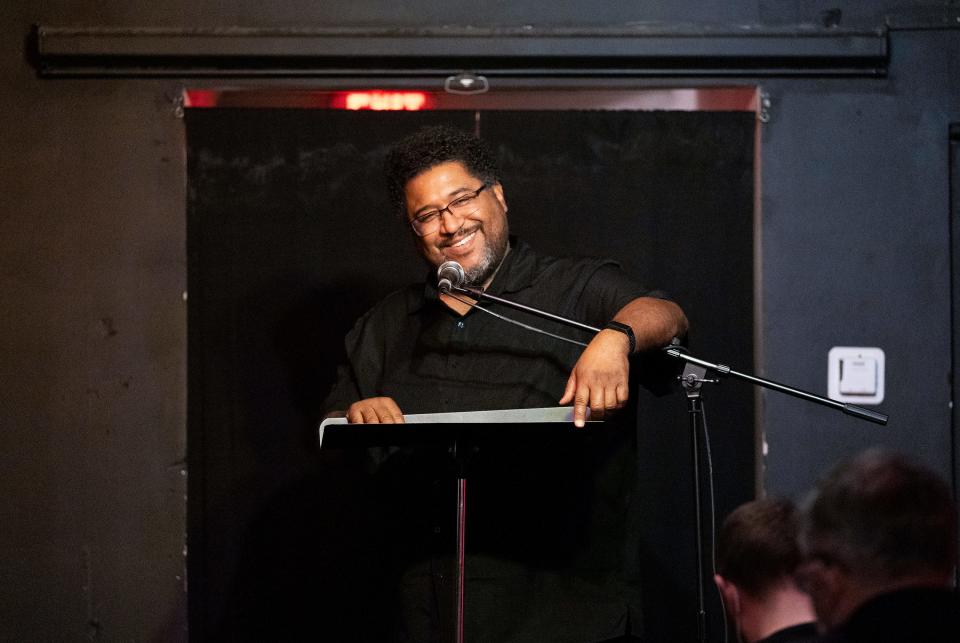 Nov 23, 2022; Columbus, Ohio, U.S.;  Scott Woods, co-founder of Writers' Block Poetry Night, one of the longest-running poetry open mics in the city, speaks to the crowd at the start of the evening. Mandatory Credit: Brooke LaValley/Columbus Dispatch