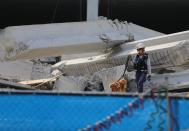 DORAL, FL - OCTOBER 10: A Miami-Dade search and rescue worker and her dog look for possible survivors in the rubble of a four-story parking garage that was under construction and collapsed at the Miami Dade College’s West Campus on October 10, 2012 in Doral, Florida. Early reports indicate that one person was killed in the collapse, at least seven people injured and one may be buried in the rubble. (Photo by Joe Raedle/Getty Images)