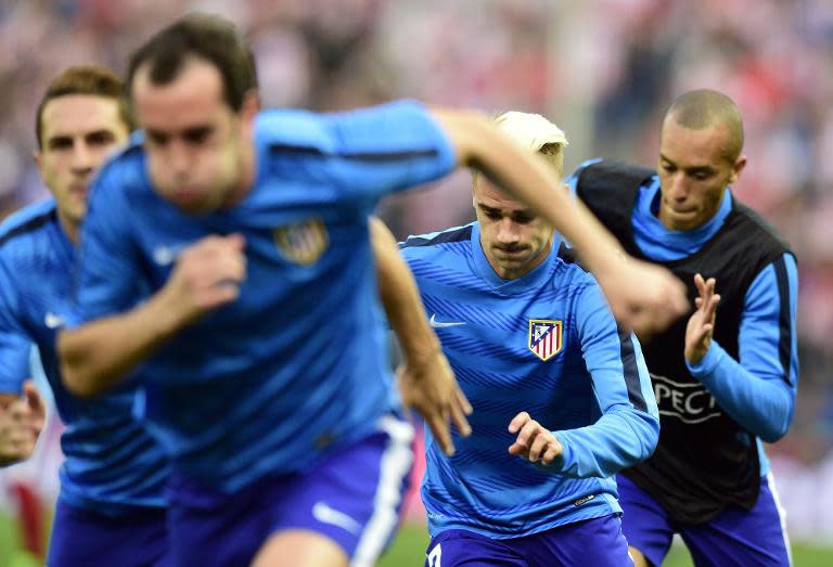 Atletico Madrid's Antoine Griezmann (2nd R) warms up with teammates before the Champions League quarter final first leg football match against Real Madrid at the Vicente Calderon stadium on April 14, 2015
