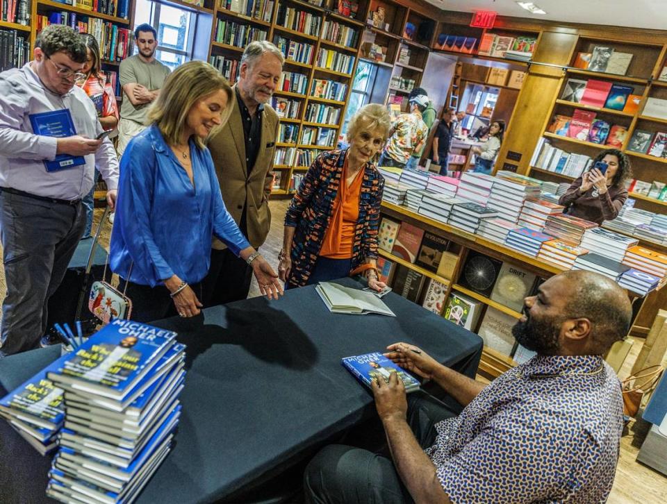 Author Michael Oher chats with from left June and Allen Morris and Dorothy Thomson, the first female mayor of Coral Gables, as he autographs his book titled “ When Your Back’s Against the Wall: Fame, Football, and Lessons Learned through a Lifetime of Adversity” to them at Books & Books in Coral Gables on Wednesday, August 23, 2023.