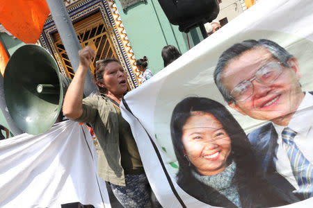 Supporters of opposition leader Keiko Fujimori hold a picture of her and her father, former President Alberto Fujimori, as they wait outside court where she is attending a hearing, in Lima, Peru October 31, 2018. REUTERS/Mariana Bazo