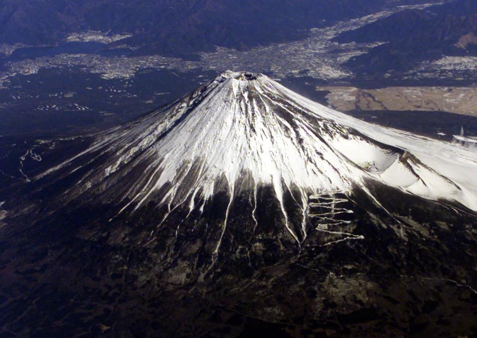 FILE - In this Thursday, Jan. 18, 2001 file photo, snow-covered Mount Fuji, Japan's highest peak, is seen from an airplane window. Japan is cheering the selection of its most iconic landmark, Mount Fuji, as a World Heritage site. The 3,776-meter-tall mountain has deep cultural and religious meaning in Japan. (AP Photo/Itsuo Inouye)