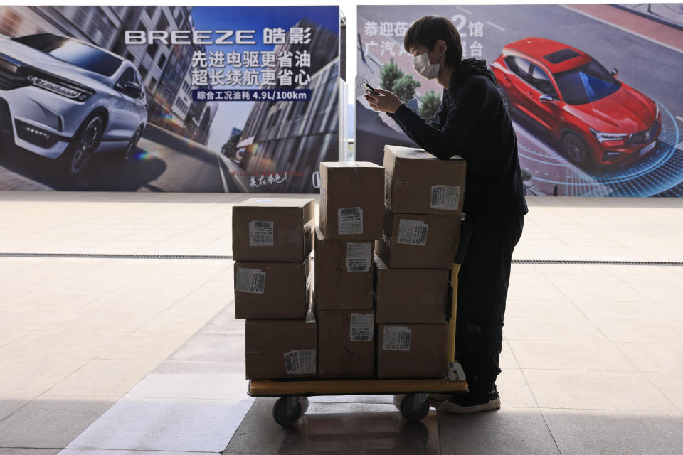 A worker prepares to deliver supplies ahead of the Auto Shanghai 2021 show in Shanghai on Sunday, April 18, 2021. Automakers from around the world are showcasing their latest products this week in the world's biggest market for auto vehicles. (AP Photo/Ng Han Guan)