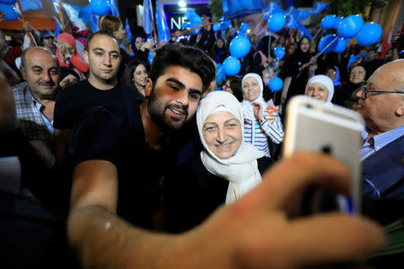 A supporter for Bahiya al-Hariri, Lebanese MP and sister of Lebanon's former Prime Minister Rafik al-Hariri, takes a selfie with a mobile phone during a campaign rally in Sidon, Lebanon April 22, 2018. Picture taken April 22, 2018. REUTERS/Jamal Saidi