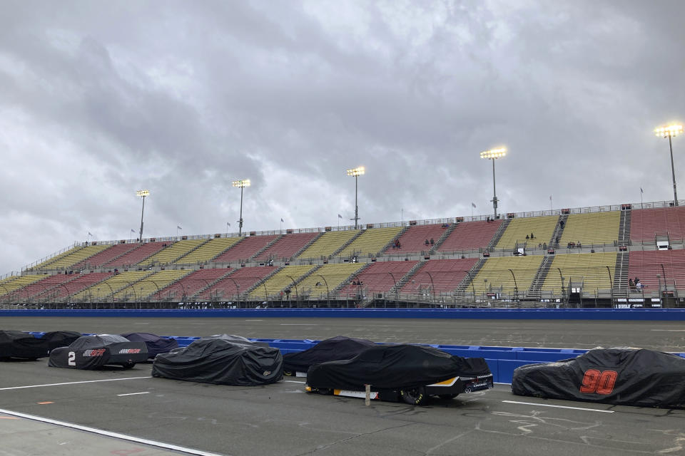 Covered race cars from the NASCAR Xfinity Series sit parked on pit road during a rain delay before the start of the race in Fontana, Calif., Saturday, Feb. 25, 2023. NASCAR has canceled practice and qualifying sessions for the weekend races at Fontana because of ongoing heavy rains. (AP Photo/Greg Beacham)