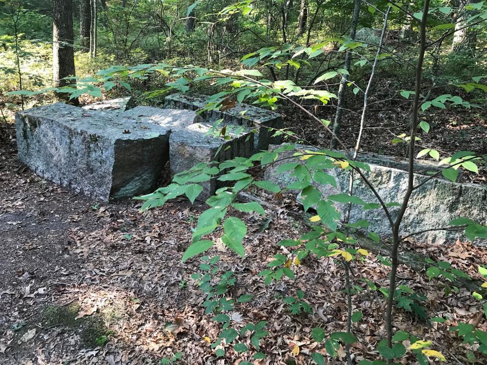Rectangular granite stones, left behind from a primitive quarrying operation, are scattered along the trail. 