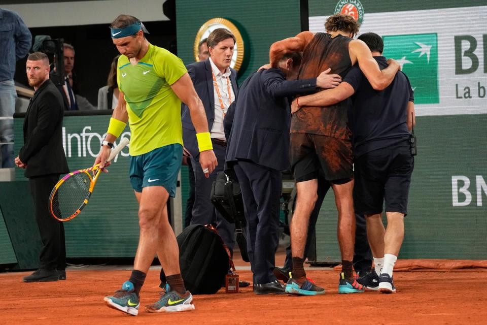 Rafael Nadal walks back as Alexander Zverev is helped off (Michel Euler/AP) (AP)