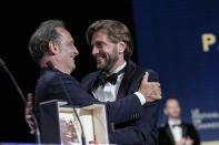 El presidente del jurado Vincent Lindon, a la izquierda, abraza al guionista y director Ruben Ostlund tras entregarla la Palma de Oro a la mejor película por "Triangle of Sadness" en la ceremonia de clausura, el sábado 28 de mayo de 2022 en Cannes, Francia. (Foto por Joel C Ryan/Invision/AP)