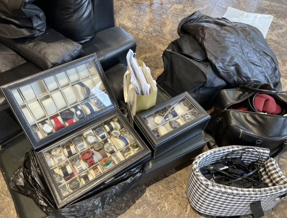 Some of Villanueva's personal effects, including dozens of fake luxury watches, that were found in a car he rented. (Marnie Luke/CBC)