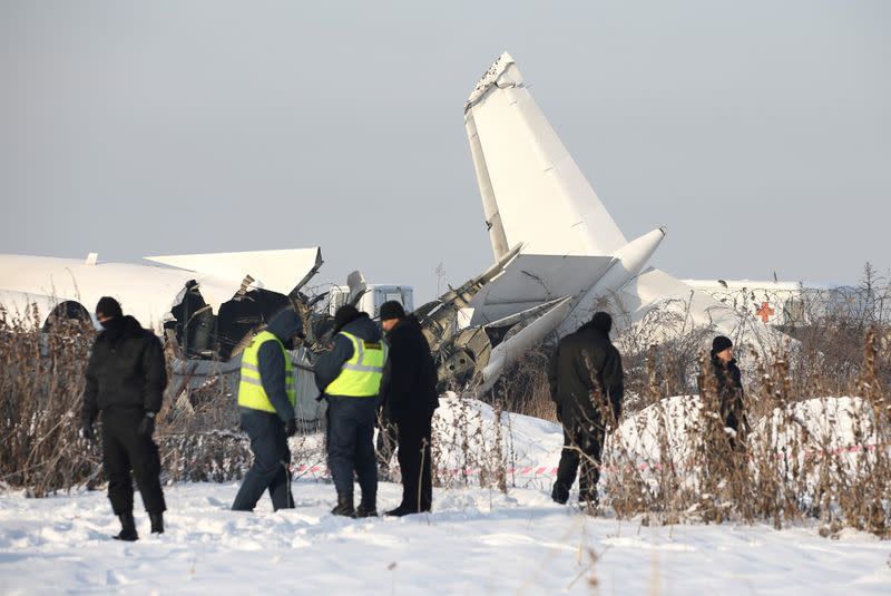 Emergency and security personnel are seen at the site of a plane crash near Almaty