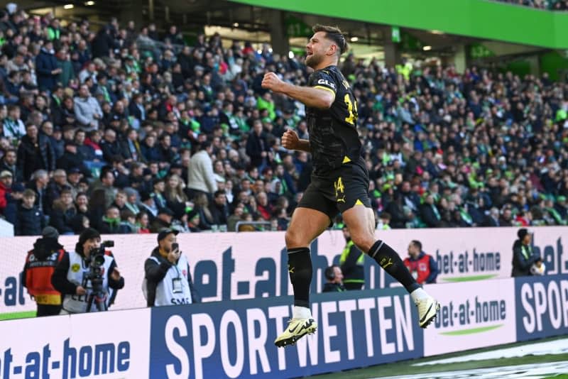 Dortmund's Niclas Fuellkrug celebrates scoring his side's first goal during the German Bundesliga soccer match between VfL Wolfsburg and Borussia Dortmund at the Volkswagen Arena. Swen Pförtner/dpa