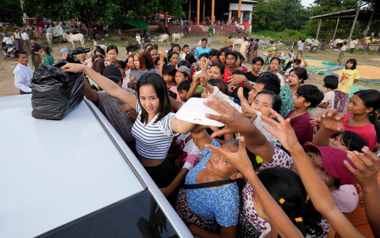 Flood victims receive relief supplies from a private donor in Naypyitaw, Myanmar