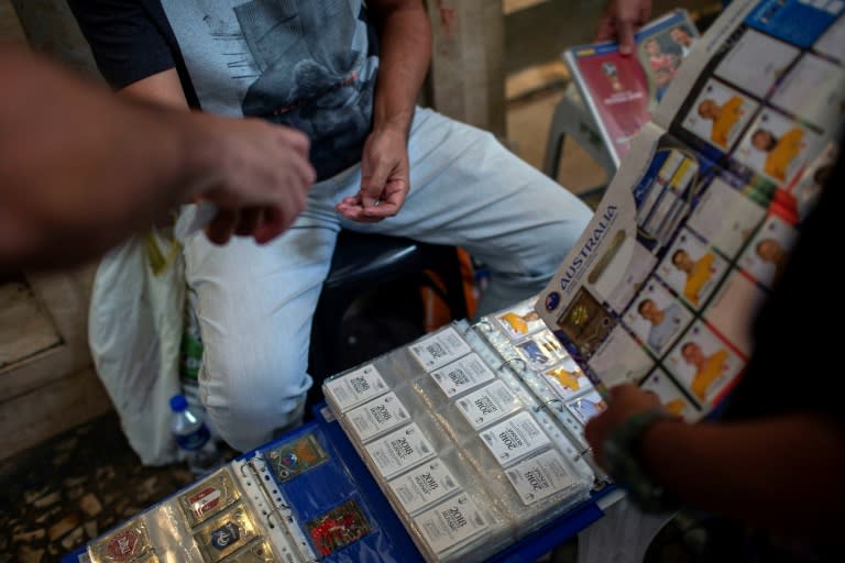 Traders and collectors meet to buy and exchange Panini World Cup football album stickers in front of a department store in downtown Rio de Janeiro