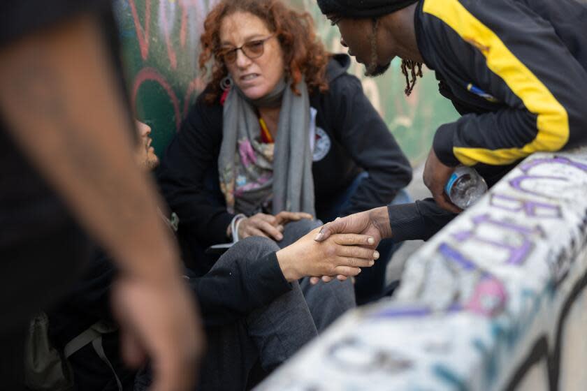 SAN FRANCISCO CA AUGUST 31, 2023 - Jabari M., right, holds hand with his overdosed friend after injecting him with two Narco's on Willow and Polk Streets on Thursday, Aug. 31, 2023 in San Francisco, Calif.