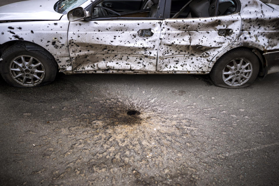 A car is photographed damaged by the shrapnel of an explosion in Irpin, in the outskirt of Kyiv, Ukraine on Saturday, April 30, 2022. (AP Photo/Emilio Morenatti)