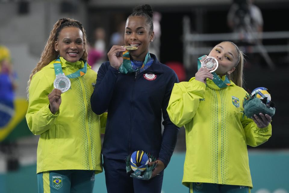 Medalists, from left, Brazil's Rebeca Andrade, silver, the United States´ Zoe Miller, gold, and Brazil's Flavia Saraiva, bronze, kiss their women's uneven bars exercise medals, on the podium of the Pan American Games in Santiago, Chile, Tuesday, Oct. 24, 2023. (AP Photo/Martin Mejia)