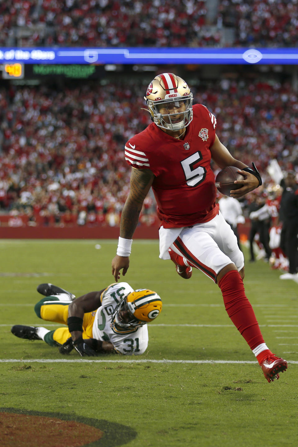 San Francisco 49ers quarterback Trey Lance (5) scores a touchdown past Green Bay Packers strong safety Adrian Amos (31) during the first half of an NFL football game in Santa Clara, Calif., Sunday, Sept. 26, 2021. (AP Photo/Jed Jacobsohn)