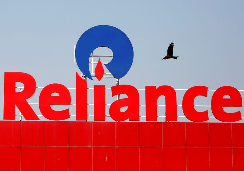 FILE PHOTO: A bird flies past a Reliance Industries sign in Ahmedabad, India