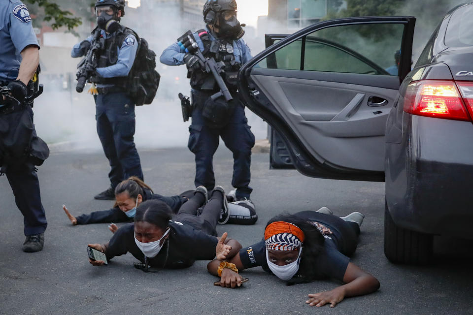 Motorists are ordered to the ground from their vehicle by police during a protest on South Washington Street, Sunday, May 31, 2020, in Minneapolis. Protests continued following the death of George Floyd, who died after being restrained by Minneapolis police officers on Memorial Day. (AP Photo/John Minchillo)