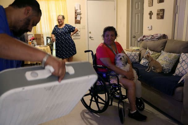 PHOTO: Jon David De Leon, with the non-profit, Eagles Flight Advocacy and Outreach, delivers a fan to Juanita Alarcon to help cope with the heat in San Antonio, Texas, July 11, 2022. (Lisa Krantz/Reuters)