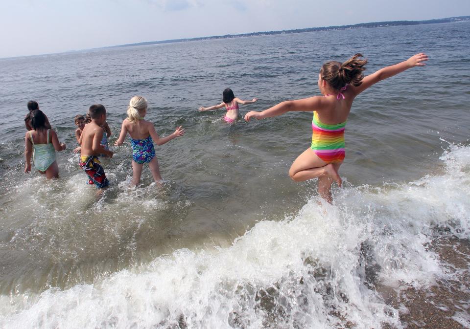 Children play in the water at Oakland Beach in Warwick.